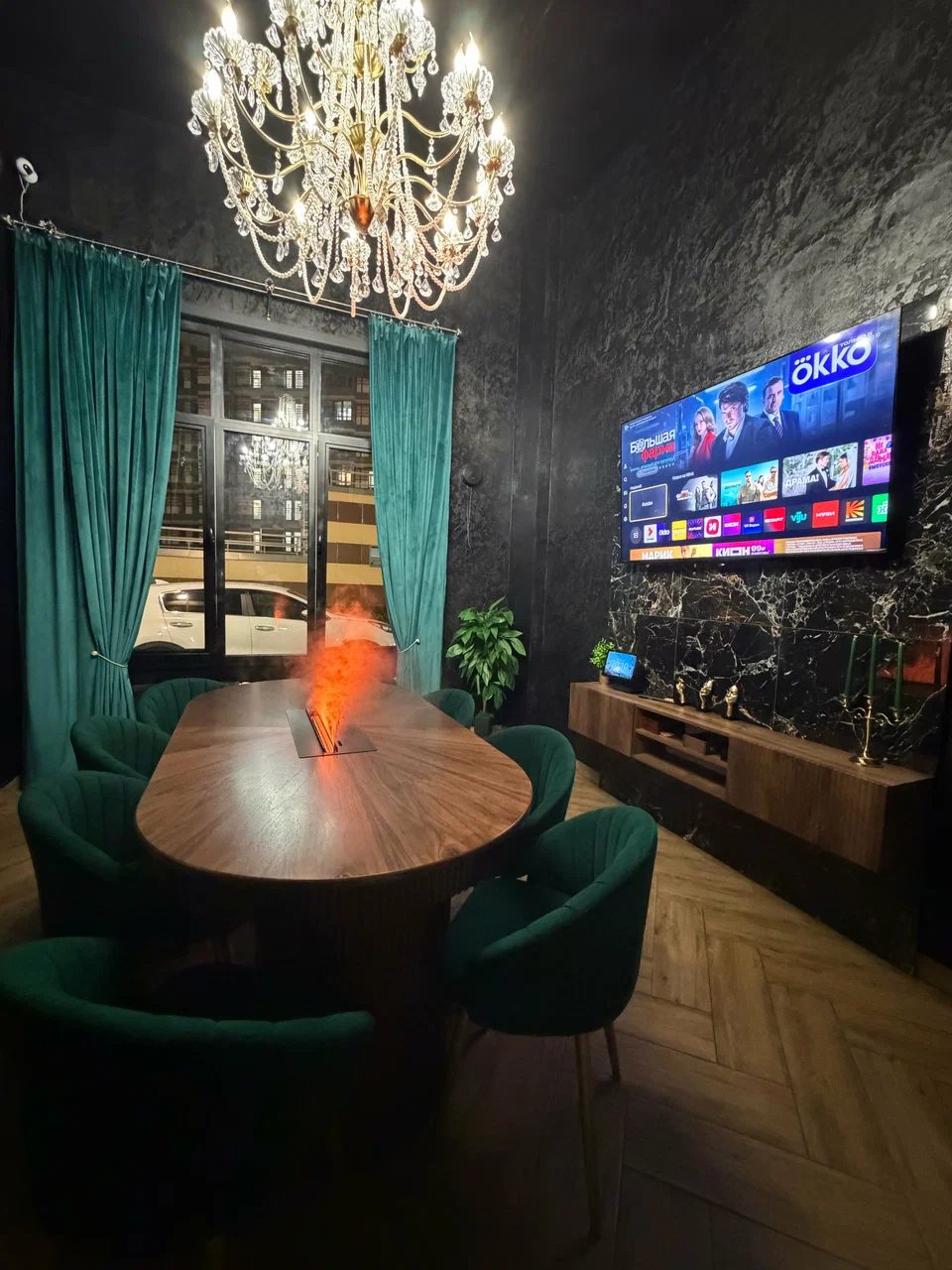 VIP-комната: овальный стол с биокамином, люстра, бархатные шторы и большой экран